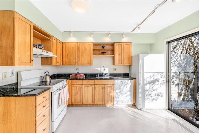 kitchen featuring sink, dark stone counters, extractor fan, white appliances, and decorative backsplash