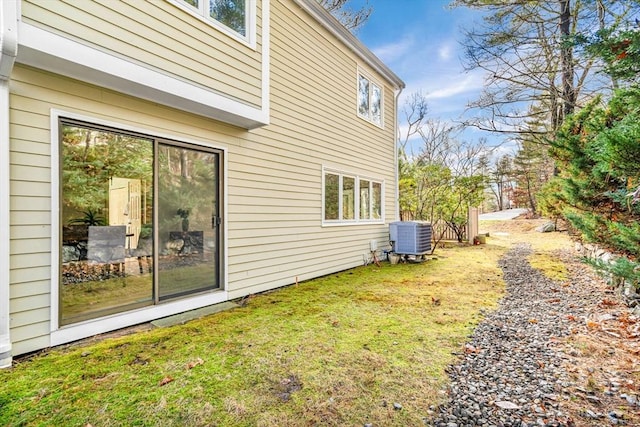 view of side of home with a yard and central AC unit