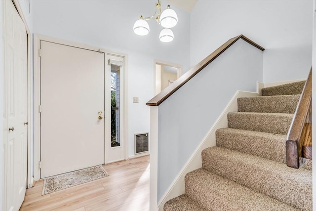 foyer entrance featuring a chandelier and hardwood / wood-style flooring