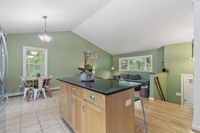 525 Flat Hill Rd, Lunenburg, MA 01462 - kitchen with dark countertops, a center island, light brown cabinetry, lofted ceiling, and a kitchen bar