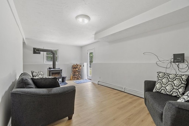 525 Flat Hill Rd, Lunenburg, MA 01462 - living room with a wood stove, a baseboard radiator, and light wood-style flooring