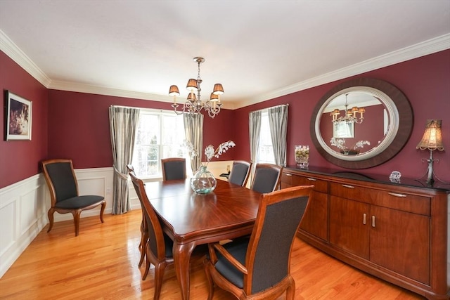 dining space featuring crown molding, light hardwood / wood-style floors, and a chandelier