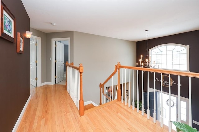 corridor featuring hardwood / wood-style floors and a notable chandelier