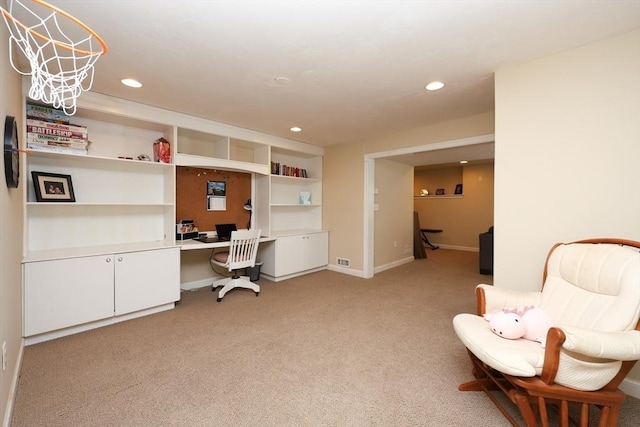 carpeted office space with built in desk