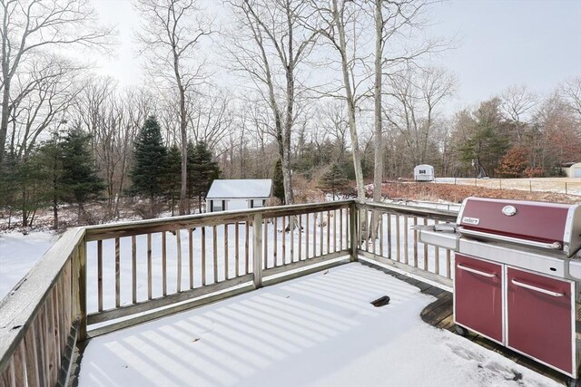 snow covered deck with a shed