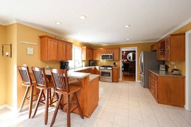 kitchen featuring crown molding, stainless steel appliances, kitchen peninsula, and a breakfast bar area