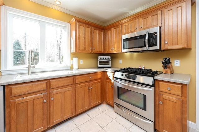 kitchen featuring ornamental molding, appliances with stainless steel finishes, sink, and light tile patterned floors