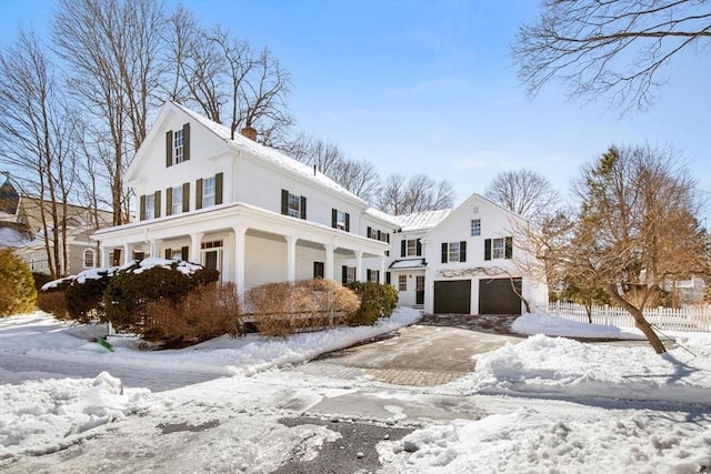 view of front of home featuring a chimney, a garage, and fence