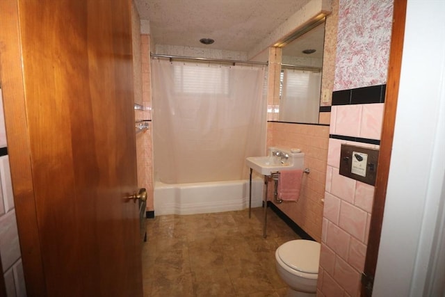 bathroom with tile walls, toilet, and shower / bathtub combination with curtain