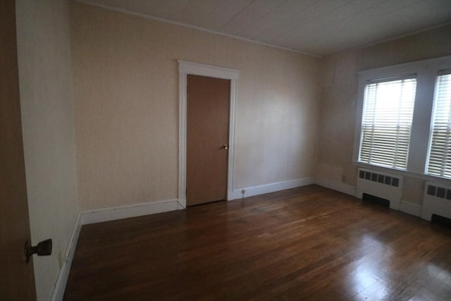 empty room featuring dark hardwood / wood-style floors and radiator