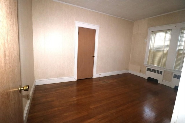 empty room with radiator and dark hardwood / wood-style floors