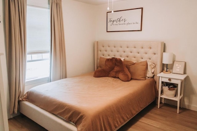 bedroom with wood finished floors and baseboards
