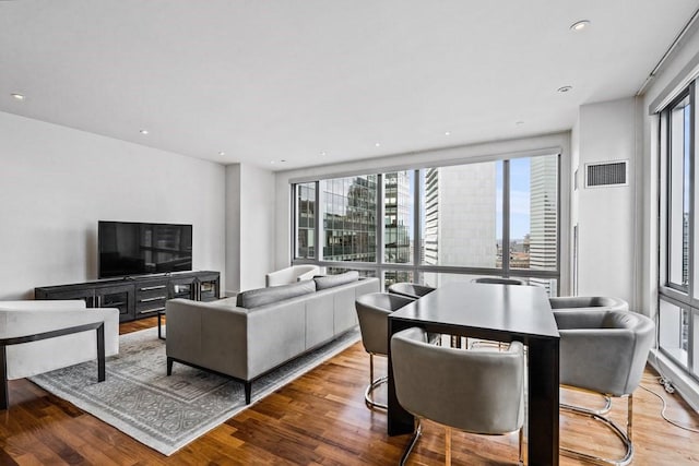 living room with recessed lighting, visible vents, and wood finished floors