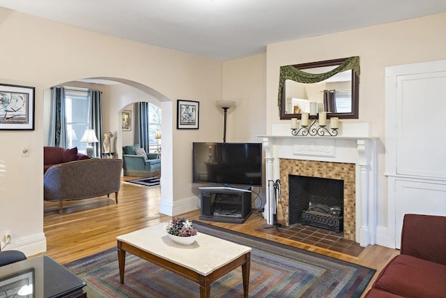 living room with hardwood / wood-style floors, a wealth of natural light, and a fireplace