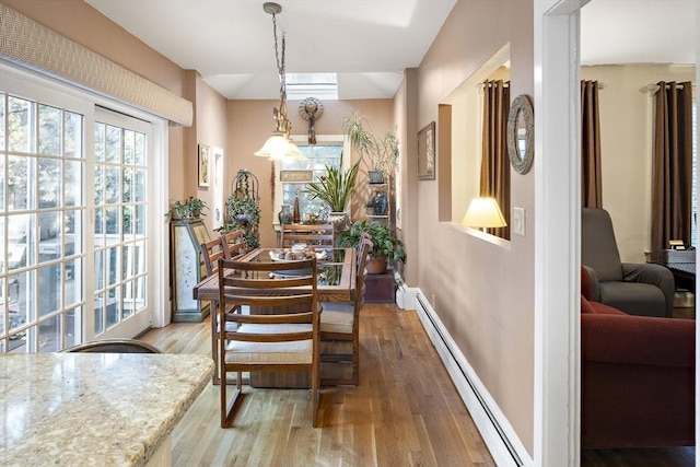 dining area featuring a baseboard radiator and wood-type flooring