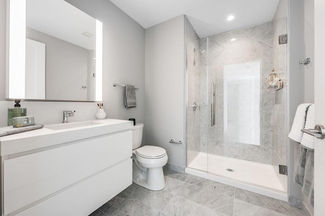 bathroom featuring vanity, a shower with shower door, and toilet