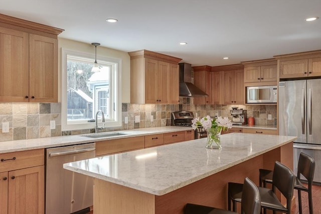 kitchen featuring a breakfast bar area, stainless steel appliances, a kitchen island, wall chimney exhaust hood, and decorative light fixtures