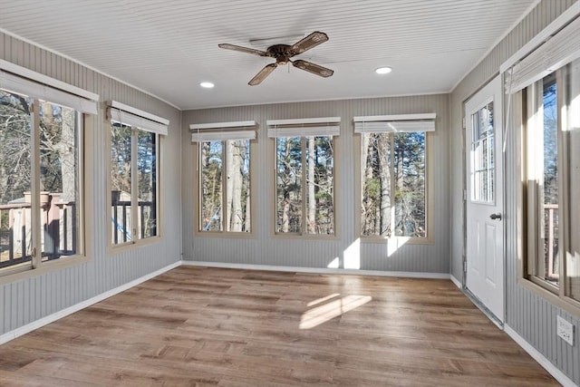 unfurnished sunroom featuring ceiling fan