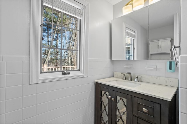 bathroom with vanity, tile walls, and wainscoting