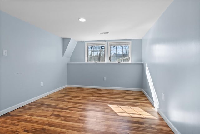 empty room with visible vents, recessed lighting, baseboards, and wood finished floors