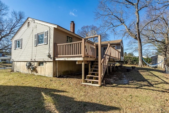 rear view of house featuring a yard, a chimney, a wooden deck, and stairs