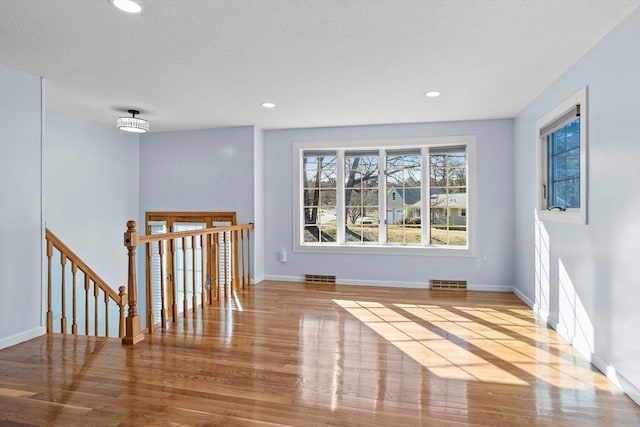 unfurnished room with recessed lighting, baseboards, and wood finished floors