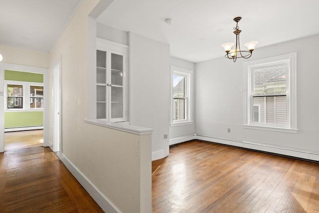 27 Chilcott Pl Unit 2, Boston, MA 02130 - unfurnished dining area with a baseboard radiator, wood-type flooring, a chandelier, and baseboards