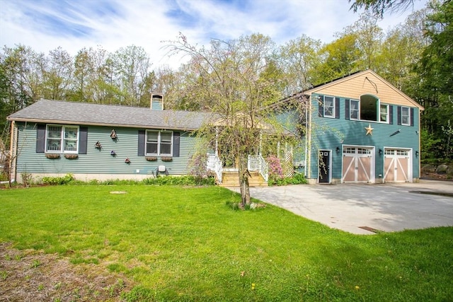 split level home with an attached garage, a chimney, concrete driveway, and a front yard