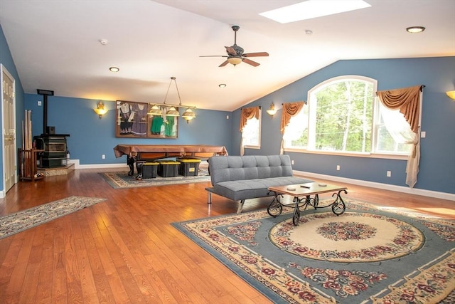 living room with a wood stove, hardwood / wood-style floors, vaulted ceiling, pool table, and ceiling fan