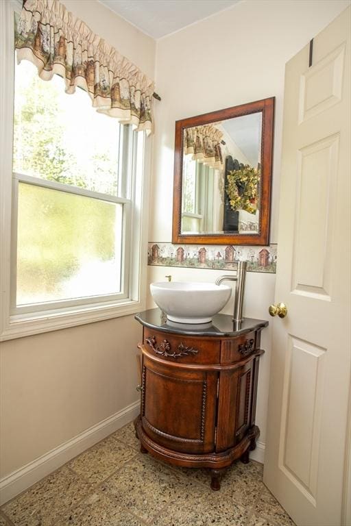 bathroom with vanity, baseboards, and speckle patterned floor