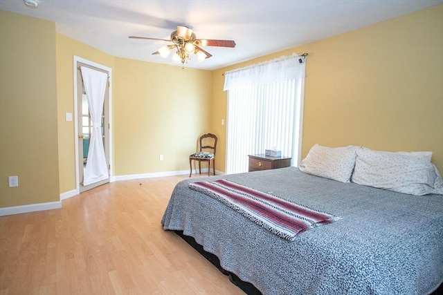 bedroom with wood finished floors, a ceiling fan, and baseboards