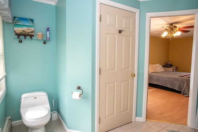ensuite bathroom featuring a baseboard radiator, tile patterned flooring, baseboards, toilet, and a ceiling fan