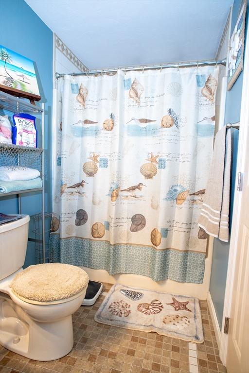 bathroom featuring toilet and a shower with shower curtain
