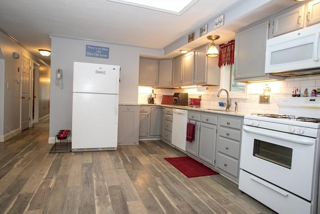 kitchen with white appliances, gray cabinets, a sink, and backsplash