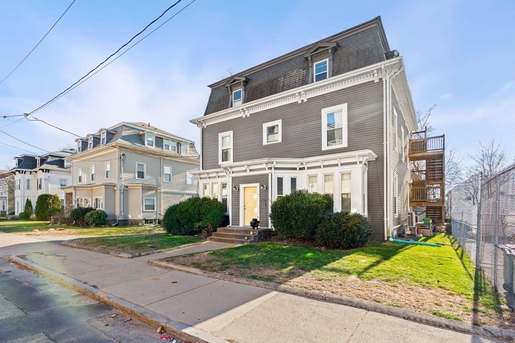 townhome / multi-family property featuring a front lawn