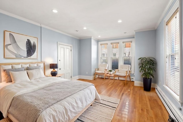 bedroom featuring light wood-type flooring, baseboard heating, and crown molding