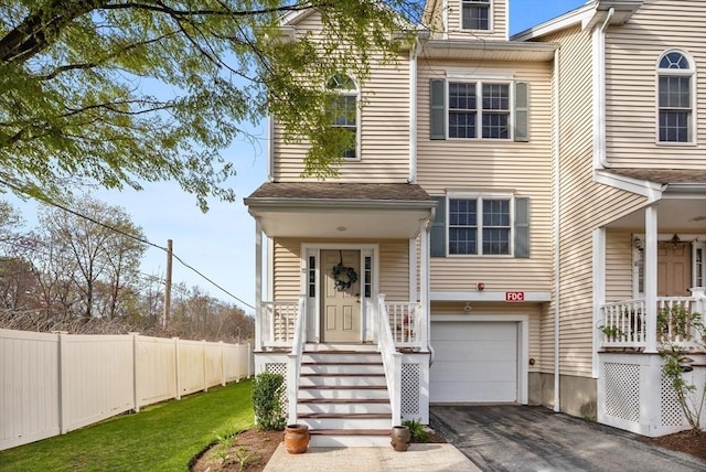 view of front of home with fence, aphalt driveway, and a garage