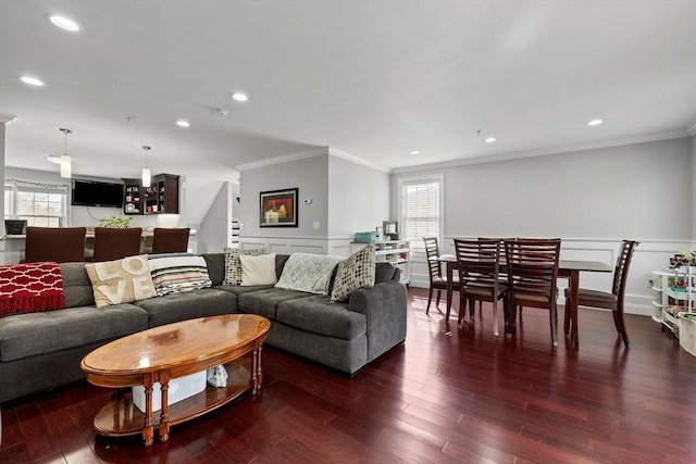 living room featuring ornamental molding, wainscoting, a decorative wall, wood finished floors, and stairway