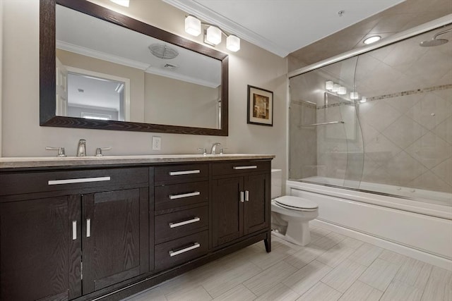 full bath with crown molding, double vanity, toilet, shower / bath combination with glass door, and a sink