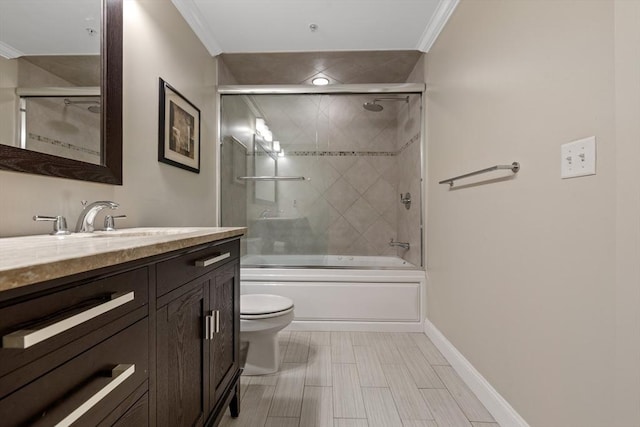 bathroom featuring crown molding, combined bath / shower with glass door, toilet, and vanity
