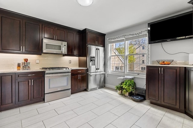 kitchen featuring light stone countertops, appliances with stainless steel finishes, and decorative backsplash