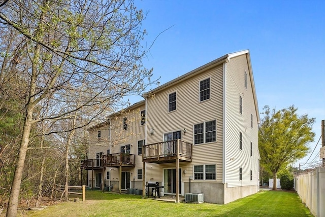 back of property featuring a lawn, fence, central air condition unit, and a deck