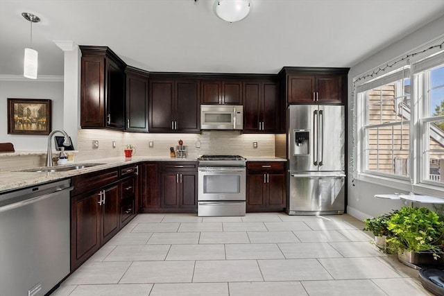 kitchen featuring a sink, appliances with stainless steel finishes, light stone countertops, and backsplash