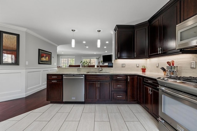 kitchen with a sink, light stone counters, backsplash, and stainless steel appliances