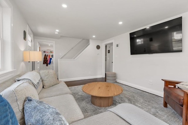 living area with recessed lighting, stairs, baseboards, and wood finished floors