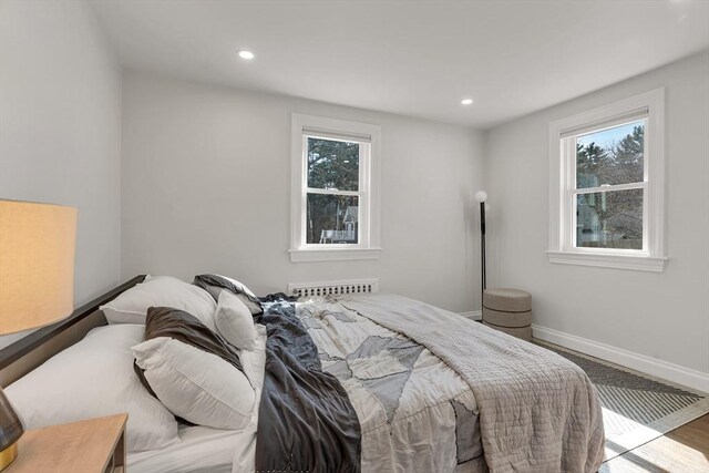 bedroom featuring baseboards, multiple windows, recessed lighting, and wood finished floors