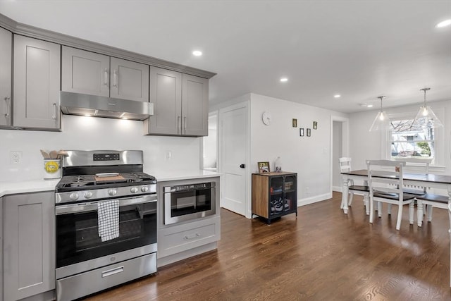 kitchen featuring gray cabinetry, under cabinet range hood, stainless steel gas range, and light countertops