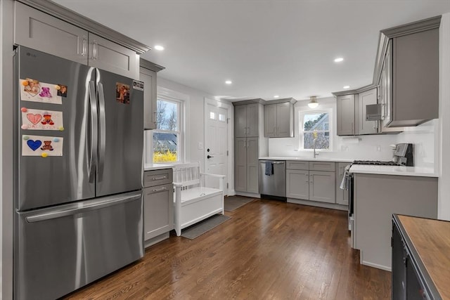 kitchen featuring dark wood-style flooring, appliances with stainless steel finishes, wooden counters, recessed lighting, and gray cabinetry