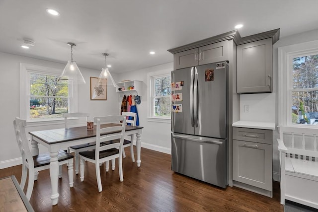 kitchen with freestanding refrigerator, baseboards, a healthy amount of sunlight, and gray cabinets