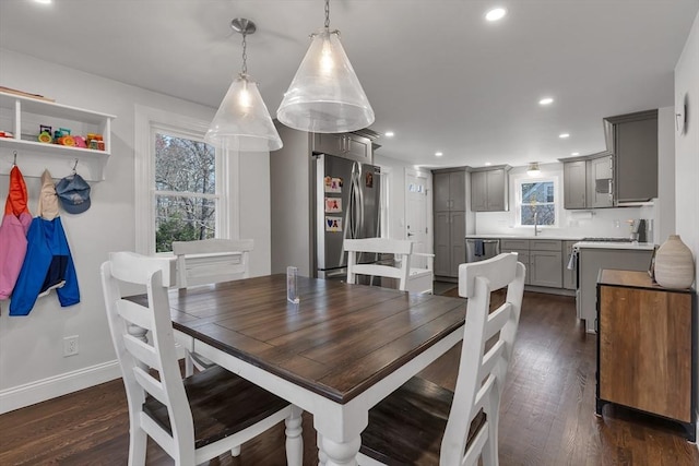dining space with baseboards, plenty of natural light, and dark wood-style floors
